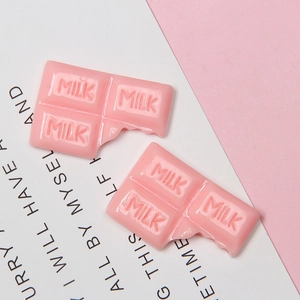 Detail of pink resin chocolate charm with MILK text and bite mark for DIY crafts