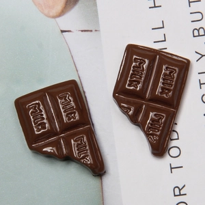 Macro detail of chocolate resin charms with MILK engraving for DIY phone case crafts