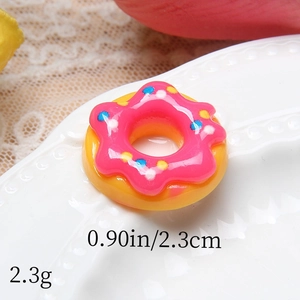 Macro detail of 2.3cm resin doughnut charm with pink frosting and colorful sugar beads