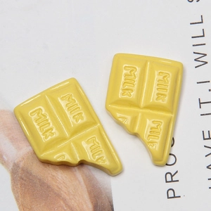 Detailed macro view of yellow resin chocolate-shaped DIY craft charm for cream glue deco