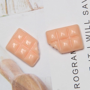 Close-up of resin salmon pink chocolate charms for DIY phone case making and crafts