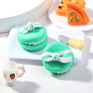 Détail macro d'une breloque macaron vert miniature avec nœud blanc pour loisirs créatifs