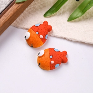 Detailed view of orange resin clownfish charms with blue dots for DIY shoe decoration