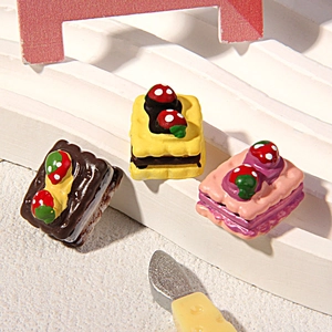 Dettaglio macro di tre pezzi di torte in miniatura in resina con fragole e texture reali