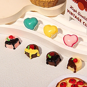 Macro shot of resin heart macarons and cherry cupcakes for DIY phone case crafts