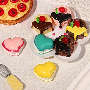 Colorful resin heart cake and macaroon miniatures set for DIY crafts on a white tray