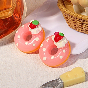 Makroansicht von rosa Harz-Donuts mit weißer Sahne und Erdbeere für DIY-Bastelarbeiten