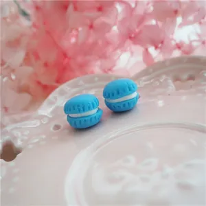 Macro shot of two blue miniature resin macarons for DIY crafts on a textured plate