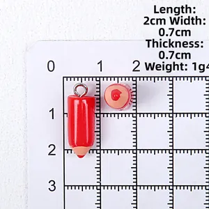 Detail view of a 2cm mini red resin pencil charm with metal loop and measurements