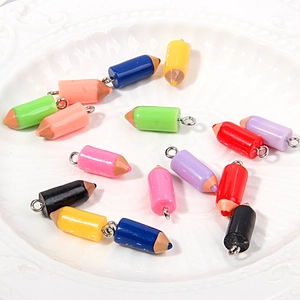 Macro shot of colorful resin 2B pencil charms with metal eyelet hooks for DIY jewelry