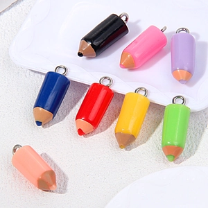 Macro shot of colorful resin pencil pendants with silver metal rings for DIY jewelry making