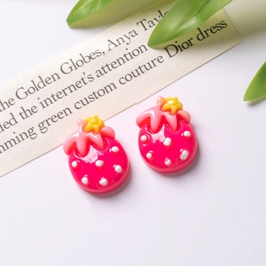 Detailed view of pink resin strawberry charms with white polka dots for DIY hair clips