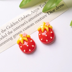 Detail of red resin strawberry charms with white polka dots for DIY hair clip crafts