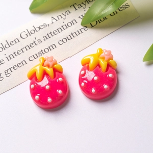 Detailed macro view of resin strawberry charms with yellow leaves for DIY hair accessories