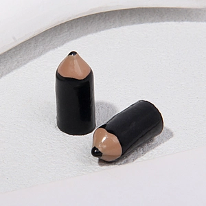 Macro shot of miniature black pencil charms for DIY crafts and jewelry making