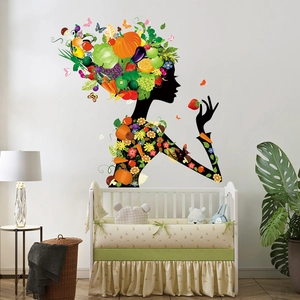 Colorful vegetable and fruit fairy wall decal above a white crib in a cozy nursery