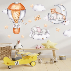 Detail of watercolor elephant and giraffe wall decals in a warm nursery setting