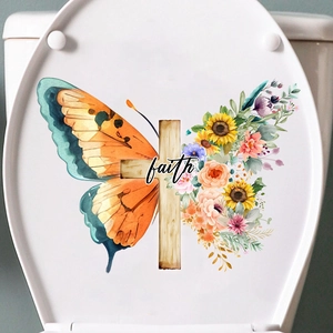 Close-up of a floral butterfly and cross sticker with faith text on a white toilet lid