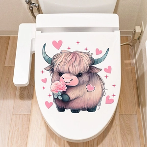 Close-up of cute Highland cow wall sticker with pink hearts on a white toilet lid