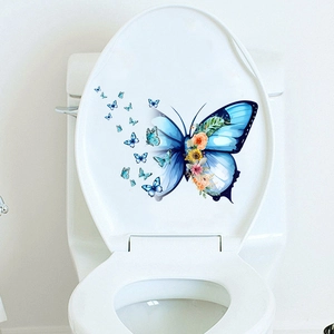 Detail of blue butterfly and flower decal on white ceramic toilet lid for bathroom decor