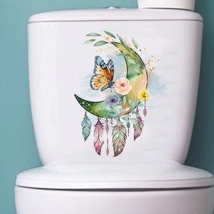 Detail of watercolor moon and butterfly sticker on a white bathroom toilet tank