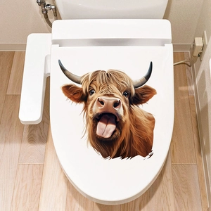 Detailed close-up of a funny Highland cow toilet sticker on a white bathroom lid