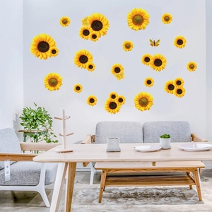 Adesivi murali con girasoli e farfalle applicati su una parete bianca di un soggiorno