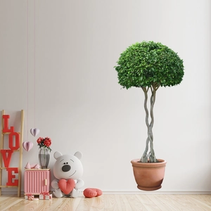 Detail of faux green plant wall sticker showing large tree design in a cozy room setting