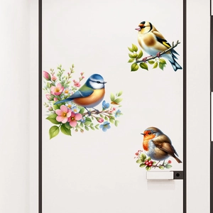 Detail of three self-adhesive bird stickers with floral branches on a white door