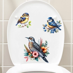 Detailed view of 3 realistic bird and floral stickers on a white toilet lid surface