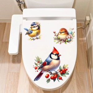 Close-up of bird and berry waterproof stickers applied on a white toilet lid surface