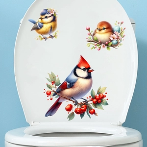 Detail of colorful bird decals with blue tit and red cardinal on white toilet lid surface