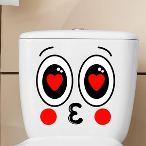 Close-up of cute cartoon face sticker with heart eyes on white bathroom toilet tank