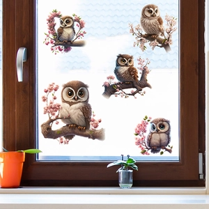 Detail of owl and pink cherry blossom wall stickers applied to a glass window pane