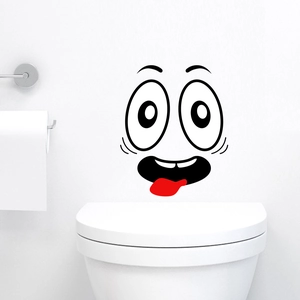 Funny smiling face sticker with big eyes and red tongue on white bathroom tile wall