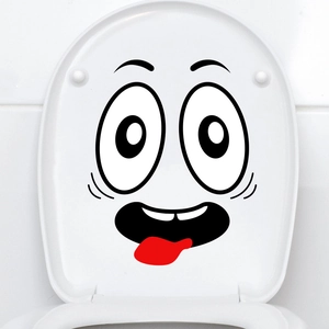 Close-up of funny cartoon face toilet sticker with large eyes and red tongue on white lid