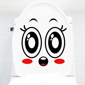 Close-up of funny cartoon surprise face sticker on a white ceramic toilet cover
