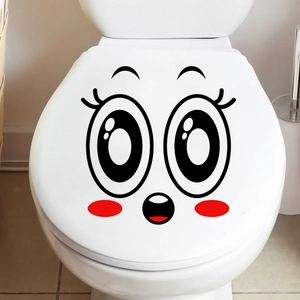 Detail of cute smiley face decal with red blush on a white bathroom toilet lid