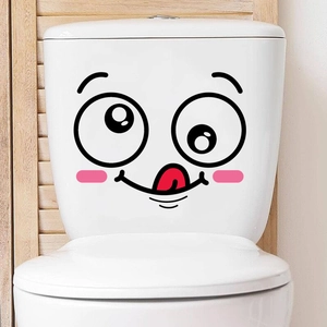 Close-up of cute cartoon smiley face sticker on a white toilet tank with pink cheeks