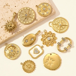 Golden stainless steel starburst and compass pendants set with cubic zirconia stones