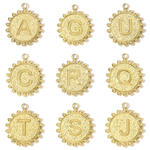 Macro detail of round gold alphabet pendants with vintage hammered texture and beads