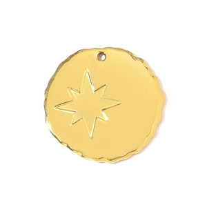 Detail of a gold stainless steel circular pendant featuring an embossed eight-pointed star
