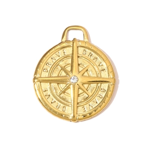 Macro shot of gold starburst compass pendant with white zircon and Brave engraving