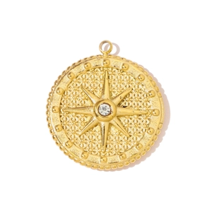Macro detail of golden starburst compass pendant with sparkling zircon stone inlay