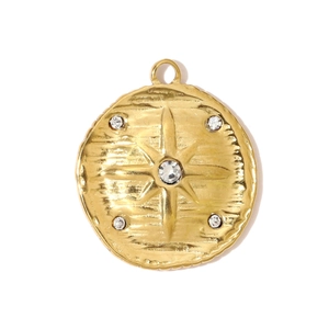 Detail of gold compass pendant featuring hammered metal texture and sparkling crystals