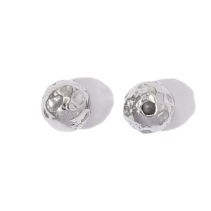 Macro view of silver stud earrings featuring cratered lunar surface texture and polished finish