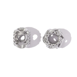 Detailed macro view of silver hollow heart and dotted textured stainless steel DIY beads