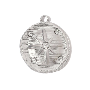 Detailed macro of stainless steel round pendant with brushed texture and starburst rhinestones