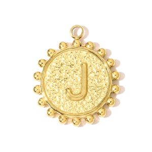 Macro shot of gold stainless steel round pendant with letter J and hammer texture