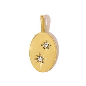 Macro detail of gold oval stainless steel pendant with starburst cubic zirconia setting